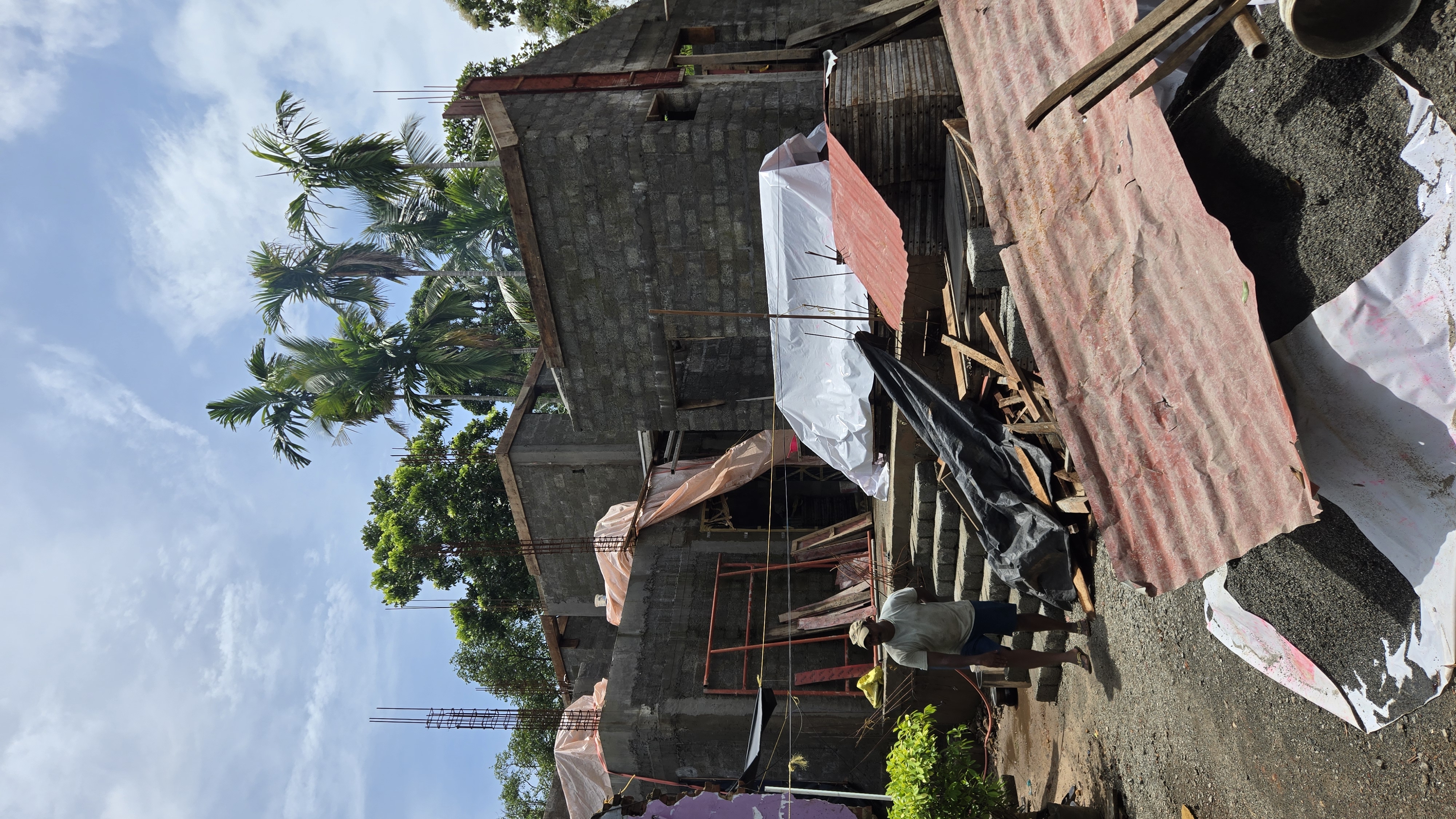 Residential project construction progress view with workers and site materials